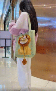 사자 얼굴 가방 속에서 얼굴을 쏙 내민 고양이, 고요한 표정 속 유쾌한 반전